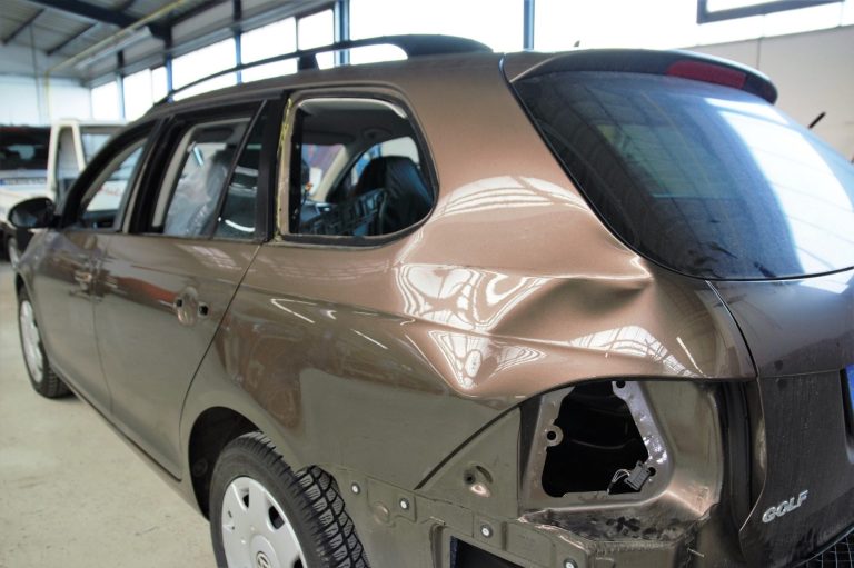 Starker Karosserieschaden Ein beschädigter brauner Kombi mit einer 40 cm. großen Dellen in der hinteren linken Seitenwand und demontierten Rücklicht.